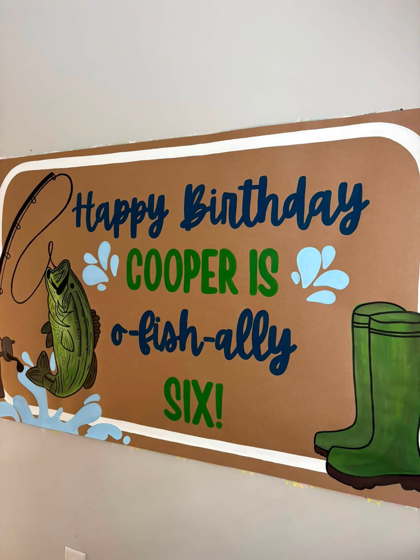 Hand-painted fishing themed sixth birthday banner with a fish, fishing rod, splashes, and green boots